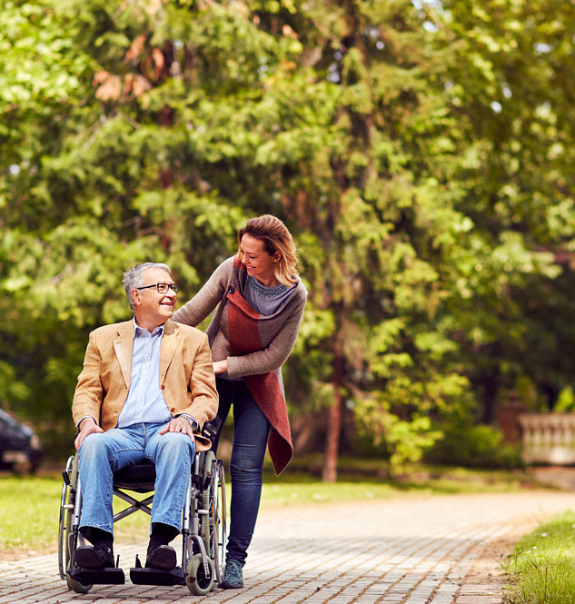 female caregiver assisting senior man on wheelchair