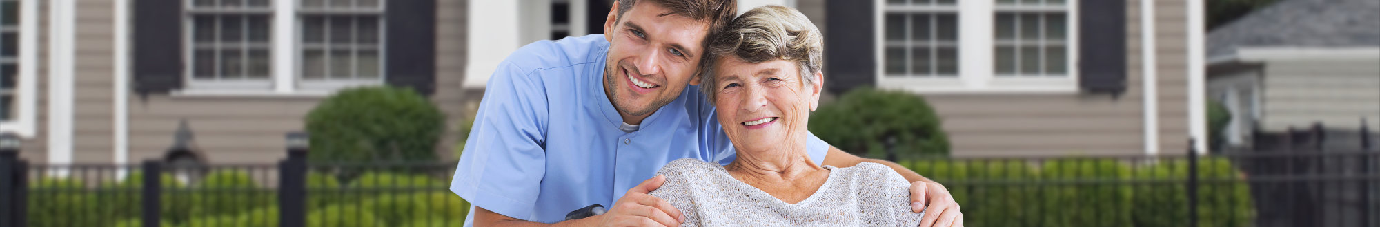 male caregiver and senior woman smiling