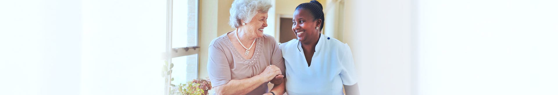 senior woman with female caregiver smiling